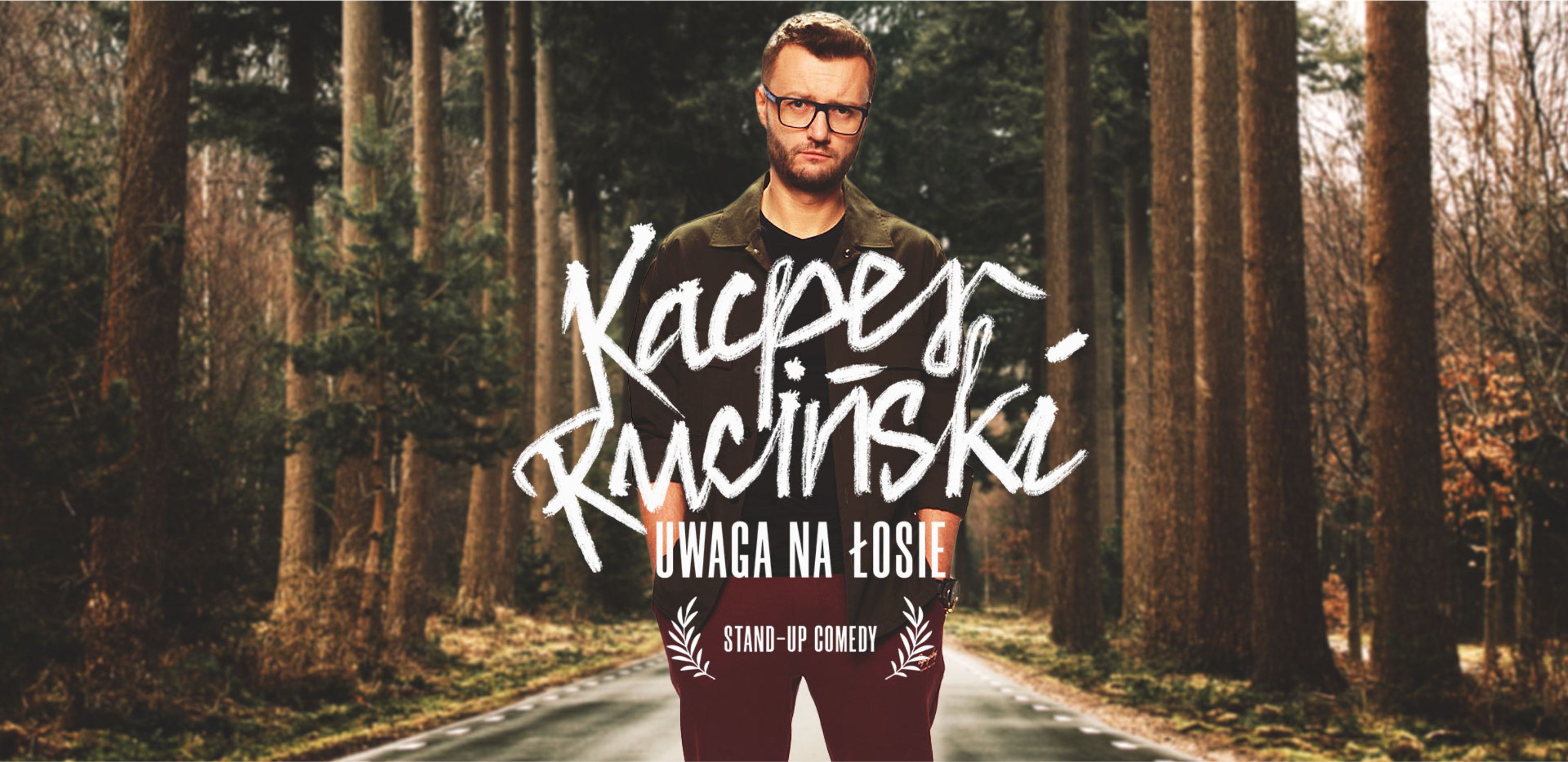 baner z wizerunkiem Kacpra Rucińskiego na tle lasu
